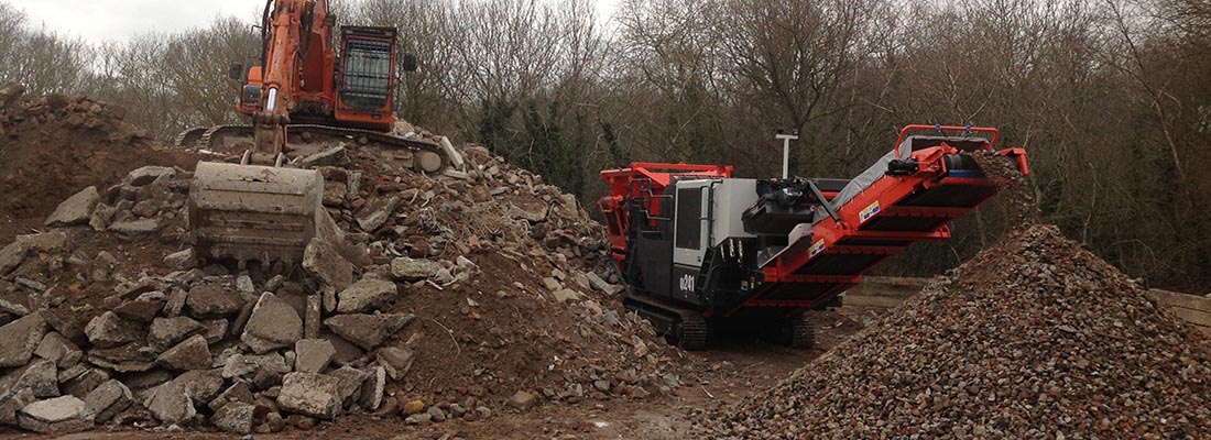 Excavator and Crusher in operation at the aggregates yard, Southampton